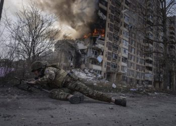 A Ukrainian police officer takes cover in front of a burning building in Avdiivka, Ukraine, Friday, March 17, 2023. The second year of Ukraine’s fight against Russia’s full-scale invasion brought no respite for Ukrainian soldiers or civilians. Associated Press photographers documented the past 12 months of death and destruction, agony and grief — as well as the glimpses of joy — that are staples of life during war. (AP Photo/Evgeniy Maloletka)