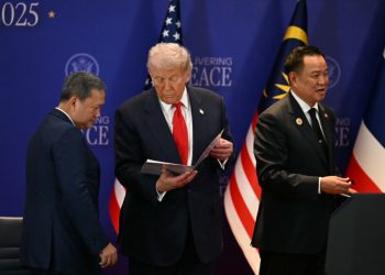 epa12483147 US President Donald Trump (C) looks at a document while standin between Cambodia's Prime Minister Hun Manet (L) and Thailand's Prime Minister Anutin Charnvirakul (R) on the sidelines of the 47th Association of Southeast Asian Nations (ASEAN) Summit in Kuala Lumpur, Malaysia, 26 October 2025.  EPA/MOHD RASFAN / POOL