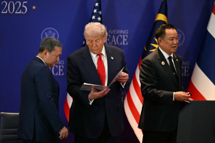 epa12483147 US President Donald Trump (C) looks at a document while standin between Cambodia's Prime Minister Hun Manet (L) and Thailand's Prime Minister Anutin Charnvirakul (R) on the sidelines of the 47th Association of Southeast Asian Nations (ASEAN) Summit in Kuala Lumpur, Malaysia, 26 October 2025.  EPA/MOHD RASFAN / POOL