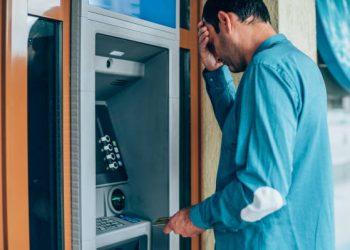 Stressful businessman holding his head because he doesn't have enough money on his credit card.