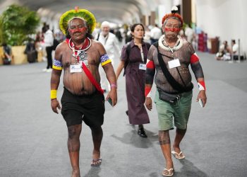 Akjabor Kaiapo, a Brazilian Indigenous activist, left, walks through the venue for the COP30 U.N. Climate Summit, Tuesday, Nov. 11, 2025, in Belem, Brazil. (AP Photo/Andre Penner)