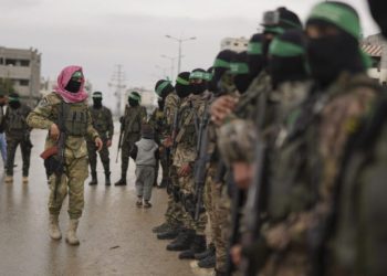 CORRECTS THE NAME OF THE CITY AS NUSEIRAT - Hamas fighters stand in formation ahead of the planned release of Israeli hostages set to be handed over to the Red Cross in Nuseirat, Gaza Strip, Saturday, Feb. 22, 2025. (AP Photo/Abdel Kareem Hana)