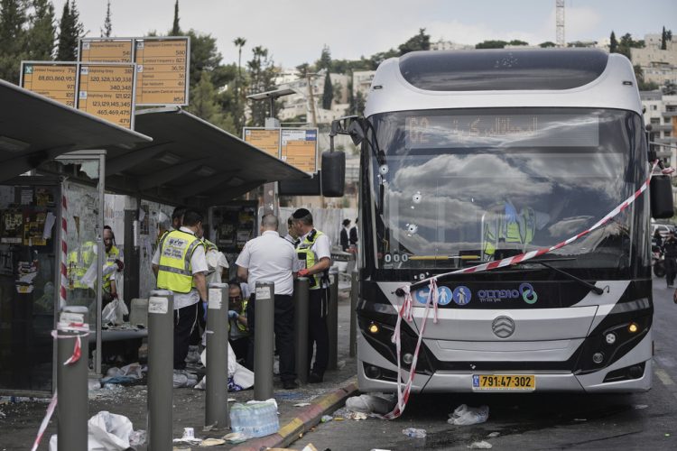Israeli police and rescue teams inspect the scene of a shooting attack carried out by two Palestinian gunmen, in which several people were killed and others injured at a bus stop in Jerusalem, Monday, Sept. 8, 2025. (AP Photo/Mahmoud Illean)