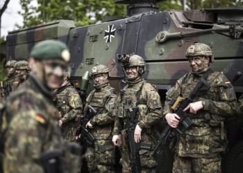 Soldiers of the German forces, Bundeswehr, stand in front of a Boxer military vehicle, a new type of armoured personnel carrier, at the Julius Leber Barracks in Berlin, Germany, Wednesday, April 24, 2024. (Henry Nicholls/Pool Photo via AP)