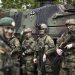 Soldiers of the German forces, Bundeswehr, stand in front of a Boxer military vehicle, a new type of armoured personnel carrier, at the Julius Leber Barracks in Berlin, Germany, Wednesday, April 24, 2024. (Henry Nicholls/Pool Photo via AP)