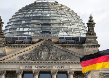A national flag of Germany waves in front of the Reichag building, home of the German federal parliament Bundestag, in Berlin, Germany, Monday, Jan. 3, 2022. Slogan reads: 'To The German People'. (AP Photo/Michael Sohn)