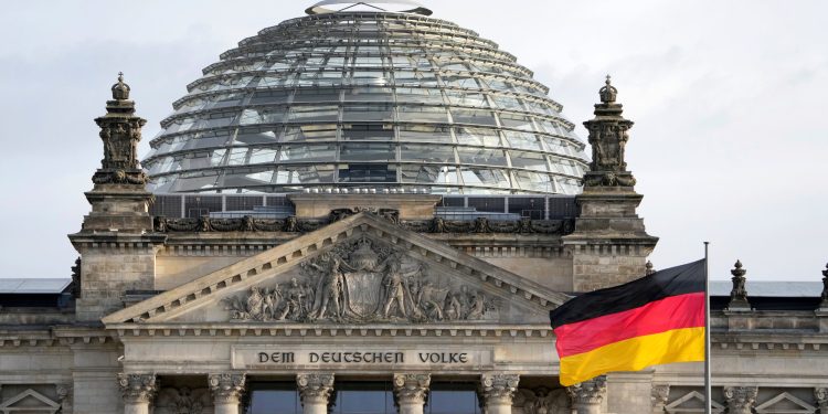 A national flag of Germany waves in front of the Reichag building, home of the German federal parliament Bundestag, in Berlin, Germany, Monday, Jan. 3, 2022. Slogan reads: 'To The German People'. (AP Photo/Michael Sohn)