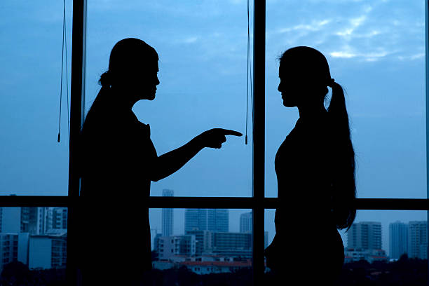 Silhouette of woman punishing her teenage daughter: generation conflict