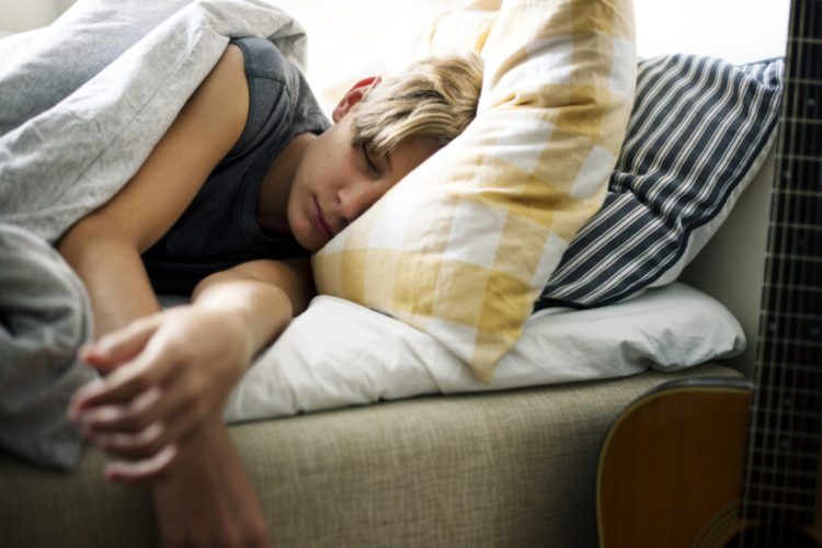 Young caucasian boy sleeping in bed