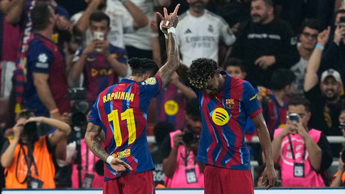 Barcelona's Raphinha, left, celebrates with teammate Lamine Yamal after scoring the opening goal during the Spanish Super Cup final soccer match against Real Madrid at King Abdullah Sports City Stadium in Jeddah, Saudi Arabia, Sunday, Jan. 11, 2026. (AP Photo/Altaf Qadri)