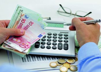 Businessman with calculator and pen counts money