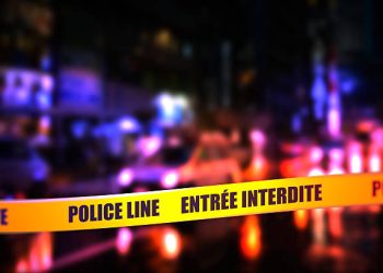 A night time street scene with focus on safety Police tape in French, "Police Line Do Not Cross". French is spoke in Belgium, Benin, Burkina, Faso, Burundi, Cameroon, Canada, Central, African, Republic, Chad, Comoros, Côte, d'Ivoire, Democratic, Republic, of, the, Congo, Djibouti, Equatorial, Guinea, France, Guinea, Haiti, Luxembourg, Madagascar, Mali, Monaco.